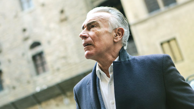 Grey haired stylish man wearing coat.