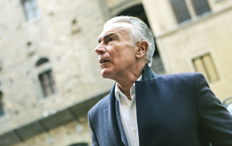 Grey haired stylish man wearing coat.